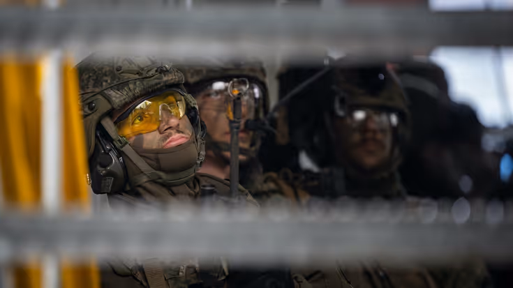 Militair met gele veiligheidsbril op tijdens oefening.