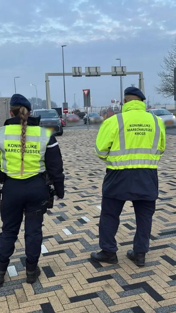 Twee marechaussees op de rug gezien tijdens een verkeerscontrole