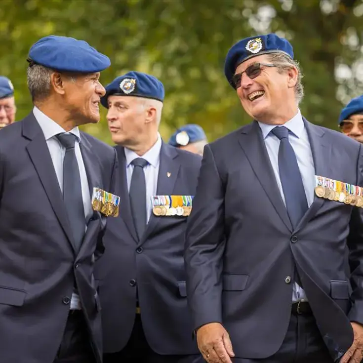 Twee veteranen zijn lachend in gesprek.