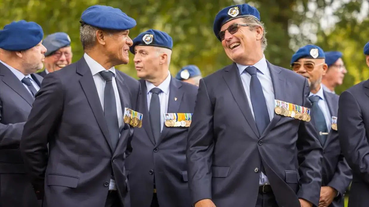 Twee veteranen zijn lachend in gesprek.