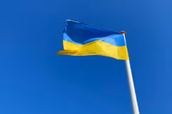 Wapperende Oekraïense vlag met blauwe lucht erachter.