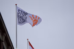 De campagnevlag wappert boven het defensiegebouw aan de Kalvermarkt in Den Haag. 