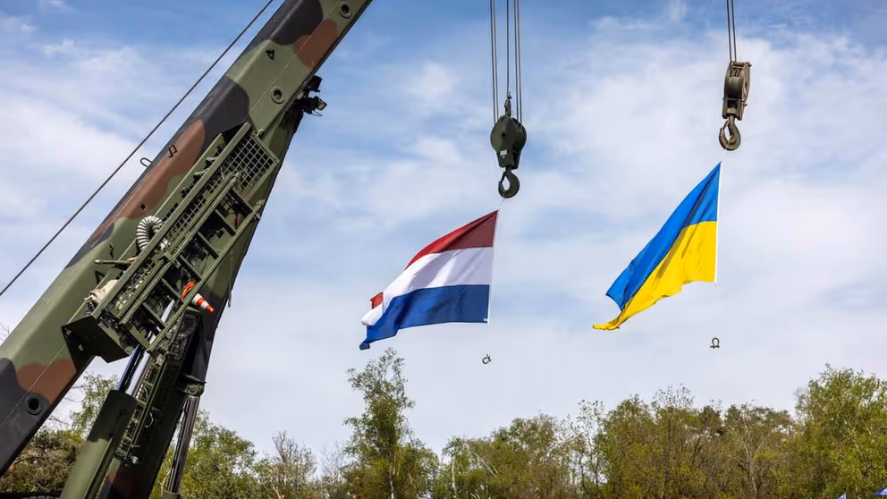 De Nederlandse en Oekraiense vlag wapperen in de lucht.