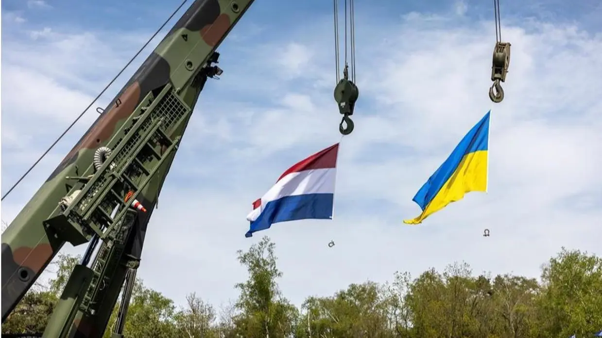 De vlaggen van Oekraïne en Nederland hangen naast elkaar aan een hijskraan.