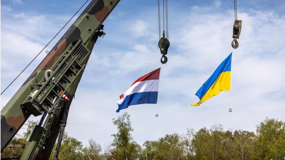 De vlaggen van Nederland en Oekraïne hangen aan een kraan. 