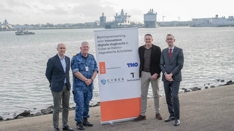 De 4 ondertekenaars staan op de kade van Den Helder met een banner tussen hen in.