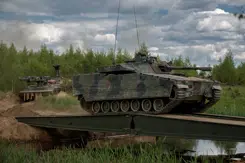 Een tank rijdt over een tijdelijke brug