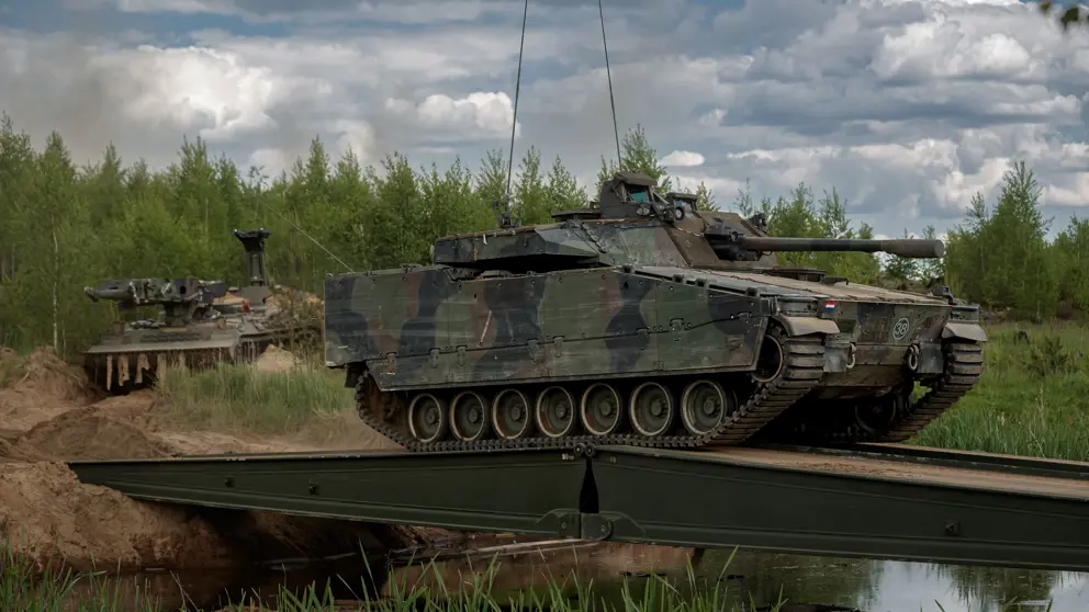 Een tank rijdt over een tijdelijke brug