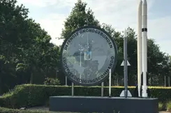Logo Defensiegebonden Luchtverdedigingscommando, met daarnaast twee raketten