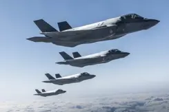 4 F-35's vliegen naast elkaar in de lucht.