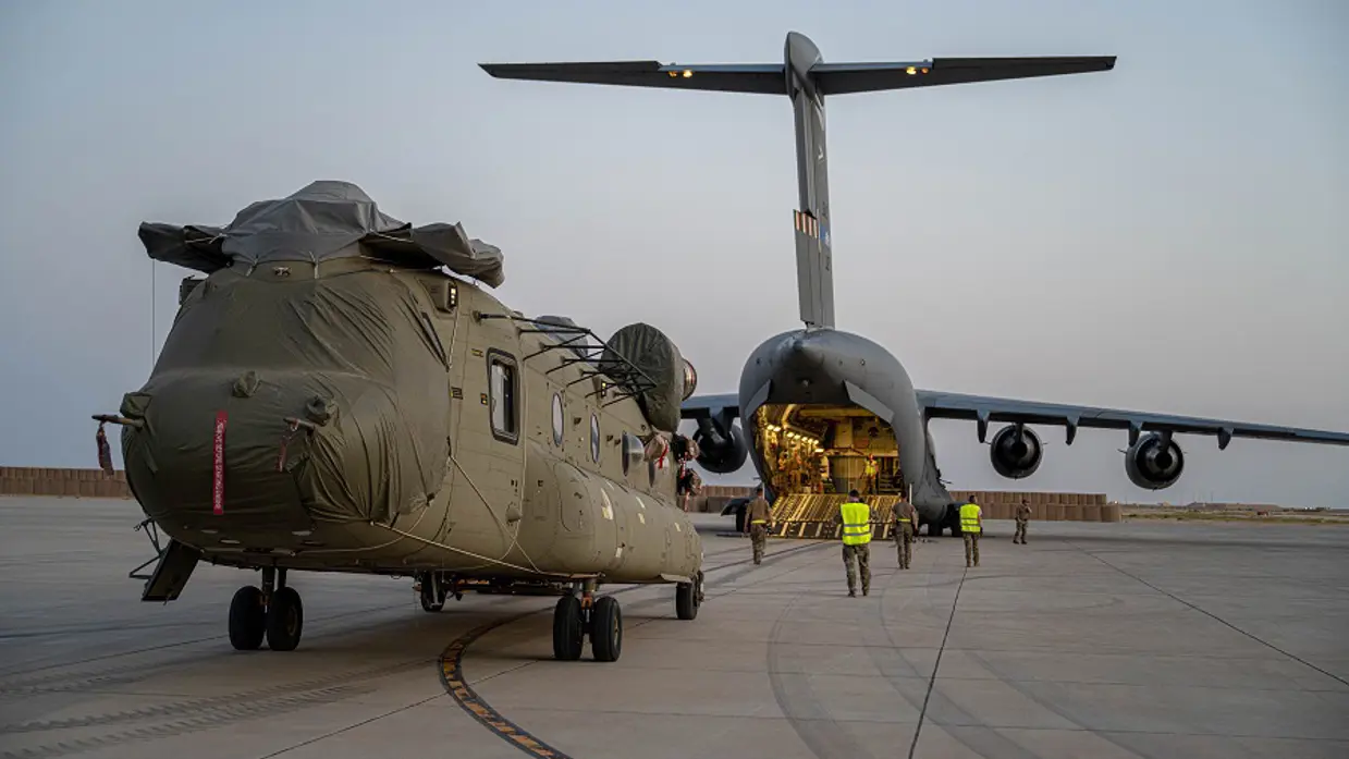 Gedemonteerde Chinook wordt in vrachtvliegtuig geladen.