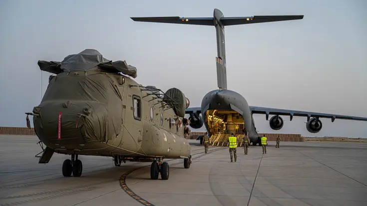 Gedemonteerde Chinook wordt in vrachtvliegtuig geladen.