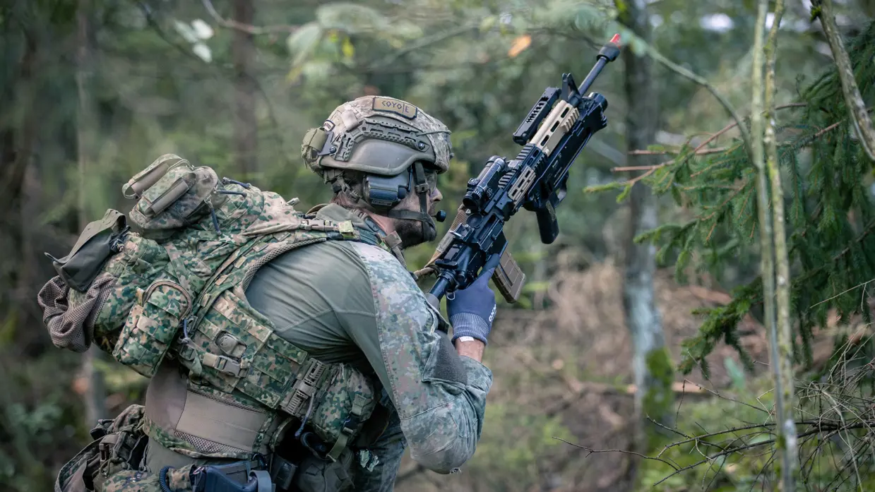 Een militair met geweer in aanslag in de Litouwse bossen