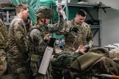 Geneeskundig personeel stabiliseert 2 door een voertuigcrash gewond geraakte soldaten.