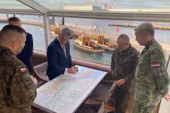 Mannen staan om een landkaart heen.