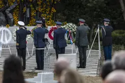 Militairen salueren bij een herdenking.