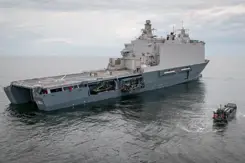 Marineschip op open zee, schuin van achteren gezien.