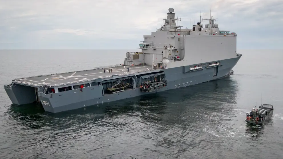 Marineschip op open zee, schuin van achteren gezien.